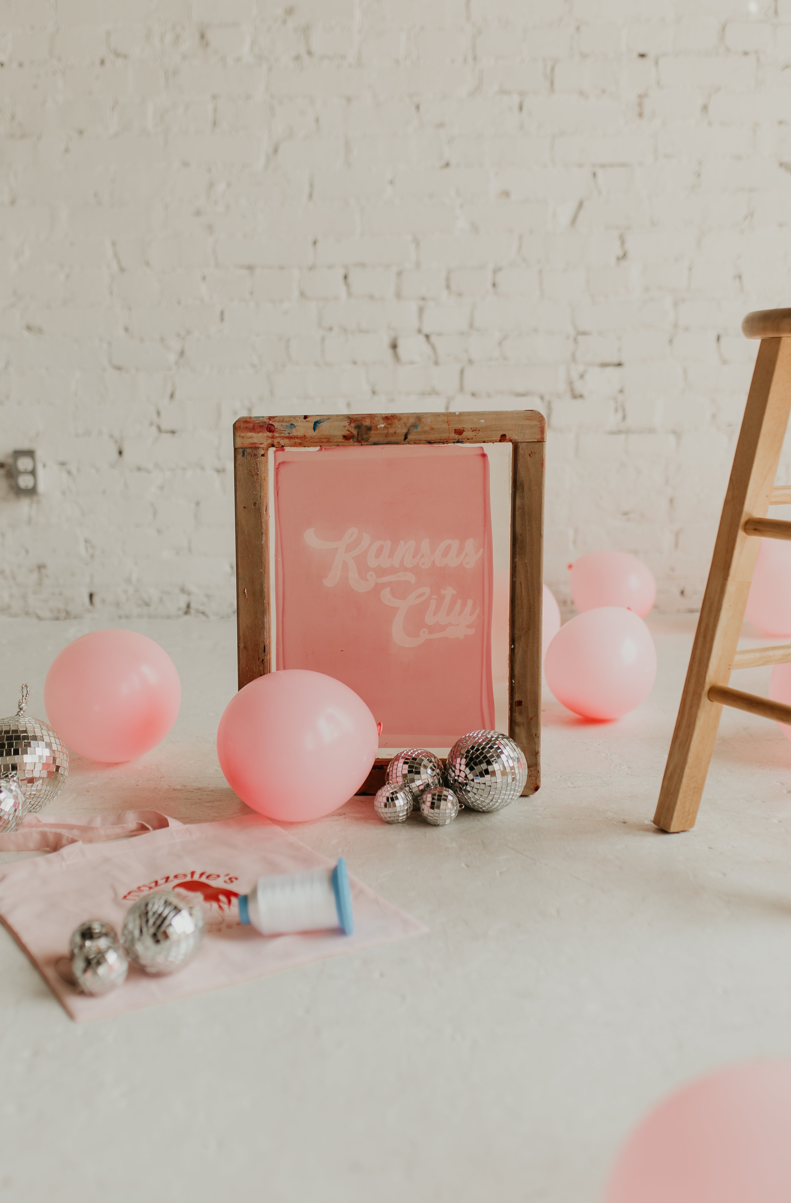 Screen print with Kansas City logo surrounded by disco balls and balloons