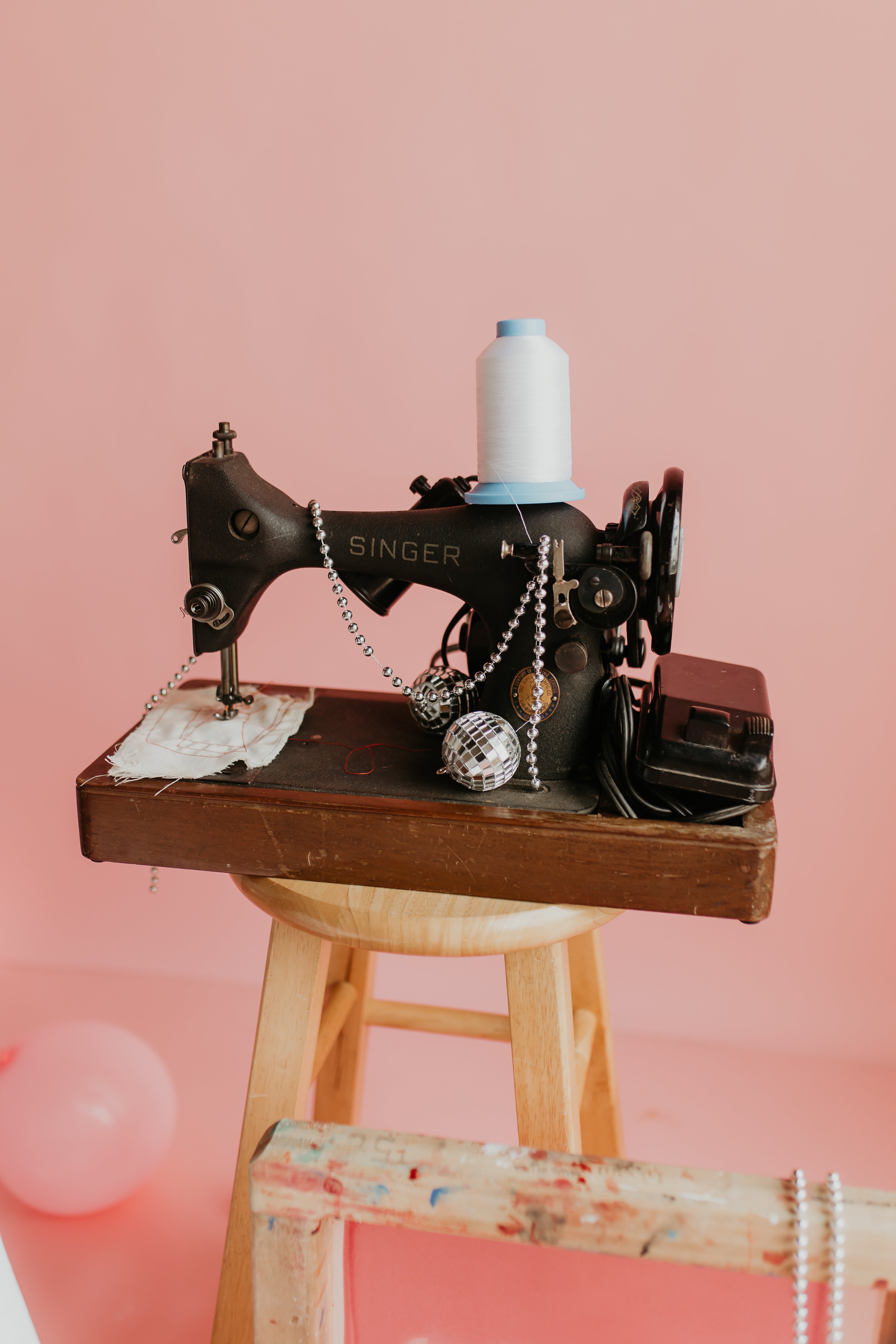 vintage sewing machine on a stool with thread and disco balls